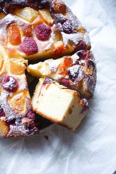 a cake that has been cut into pieces and is sitting on wax paper with powdered sugar