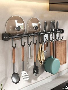 a kitchen wall with pots, pans and utensils hanging on the hooks