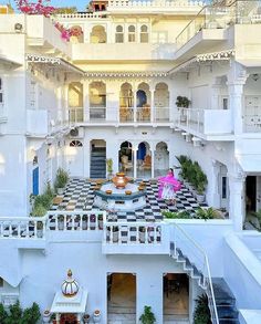 an elaborately decorated white building with stairs and balconies on the second floor