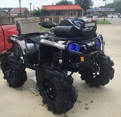 a large four wheeler parked in front of a red truck