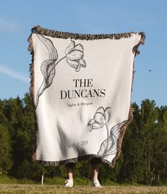 a person standing in front of a white blanket with the words the duncans on it