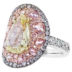 Step into a world of extraordinary craftsmanship with this one-of-a-kind diamond ring, by Belgian jewelry designer Joke Quick. At its heart is a 3-carat pear-shaped rose-cut yellow diamond, surrounding it are fancy pink brilliant and rose-cut diamonds, creating a symphony of texture and sparkle. And framing it all, a striking blue diamond halo adds a bold, unforgettable finish. Peek beneath the center stone, and you’ll find a hidden surprise: pave-set pink diamonds. Handmade in Belgium with trad Pear Shaped Diamond Ring, Blue Diamond Ring, Yellow Diamond Rings, Fancy Yellow Diamond, Cluster Rings, Gold Cocktail Ring, Diamond Cocktail Rings, Antique Pink, Rosa Pink