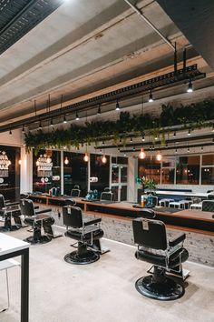 the interior of a barbershop with chairs and lights