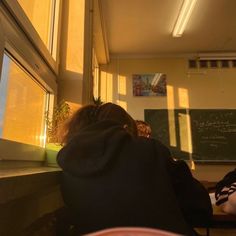 two people sitting at a table in front of a blackboard with writing on it