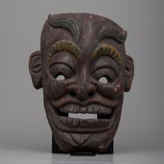 a wooden mask with two horns on it's head and one eye open to the side