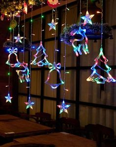 some lights that are hanging from the ceiling in front of a table with chairs and tables