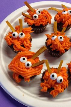 cupcakes decorated with orange frosting and googly eyes on a white plate