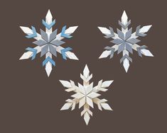 three snowflakes are shown on a brown background, one is white and the other is blue