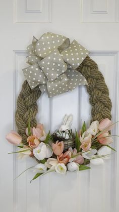 a wreath on the door with flowers and polka dot fabric hanging from it's side