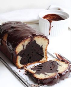 a loaf of chocolate marbled bread on a cooling rack next to a cup of coffee