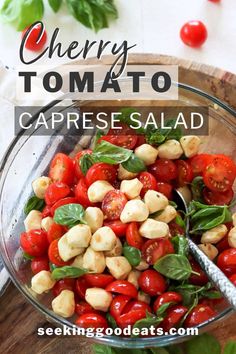 cherry tomato caprese salad in a glass bowl with basil and tomatoes on the side