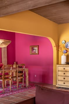 a living room filled with furniture and pink walls