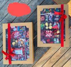 two boxes with different types of candies in them on a wooden table next to each other