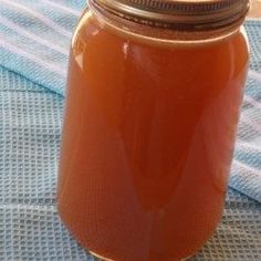 a glass jar filled with liquid sitting on top of a blue cloth covered tablecloth