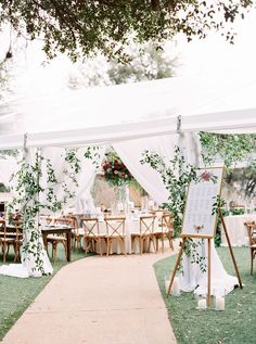 an outdoor tent with tables and chairs set up for a wedding