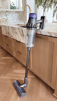 a vacuum cleaner is on the floor in a kitchen