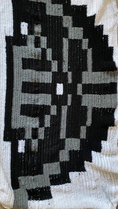 an old black and white rug on the floor with some sort of design in it