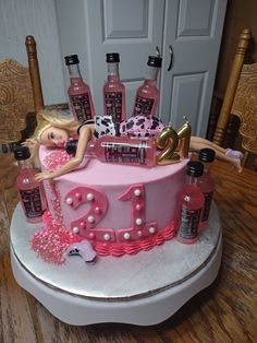 a birthday cake that is decorated with pink and black decorations, including a barbie doll