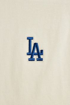 the los angeles dodgers logo is embroidered on a white t - shirt with blue letters