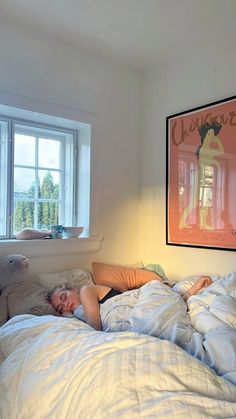 a woman laying in bed with her head on the pillow