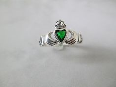 Gorgeous dainty sterling silver CLADDAGH ring with a heart shaped rich green lab Emerald at its center. 11mm at its widest. Nice detail, great for any finger. Stamped 925. Non tarnish. Silver Heart Ring For May Birthstone Gift, Silver Heart Cut Emerald Ring As Gift, Silver Heart Cut Emerald Ring For Gift, Silver Claddagh Ring, Irish Rings, Celtic Ring, Friendship Ring, Claddagh Ring, Friendship Rings