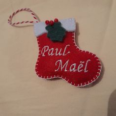 a red christmas stocking ornament hanging on a white sheet with the words paul mael