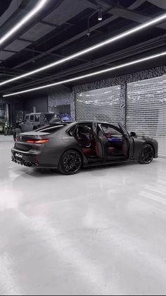 two cars parked in a garage with their doors open