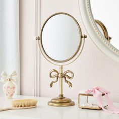 a mirror sitting on top of a white counter next to a brush and comb dryer