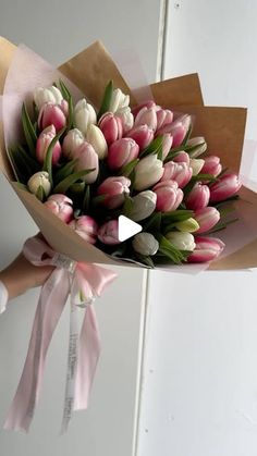 a bouquet of tulips wrapped in pink and white paper