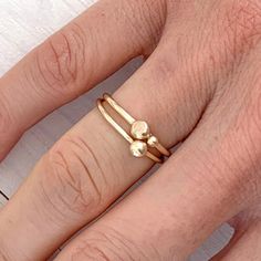 A dainty minimalist ring with two gold balls perched on top of a 1.5mm gold band in 100% recycled gold, this is the perfect ring for a lover of all things delicate and understated. With a small bead leaning against the larger one, these gold balls resemble a mother and baby nestled against each other, thus making this ring a perfect gift for a mum. Both gold balls have a flatter, textured side, adding some interest to an otherwise perfectly geometric piece of jewellery. Made in solid gold, this Minimalist Recycled Gold Stackable Toe Rings, Minimalist Stackable Midi Rings In Recycled Gold, Minimalist Stackable Recycled Gold Midi Rings, Minimalist Stackable 14k Gold-filled Toe Rings, Minimalist 14k Gold-filled Stackable Toe Rings, Minimalist 14k Gold Filled Stackable Toe Rings, Minimalist Recycled Gold Stackable Promise Rings, Minimalist Stackable Rings In Recycled Gold, Minimalist 14k Gold-filled Midi Toe Rings