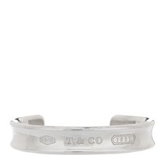 This is an authentic TIFFANY Sterling Silver 1837 Cuff Bracelet. The bracelet is crafted of sterling silver and features the signature 1837 T&Co logo engraved along the center of a concave cuff. Co Logo, Cuff Bracelet, Cuff, Bracelet, Sterling Silver, Silver