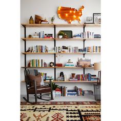 a living room filled with furniture and bookshelves next to a wall mounted map