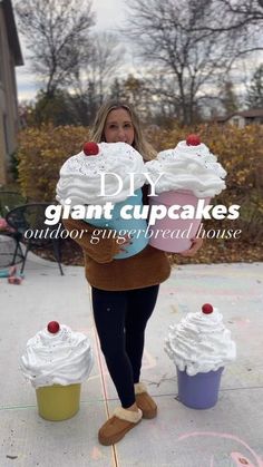 a woman holding two giant cupcakes in front of her face with the caption diy giant cupcakes outdoor gingerbread house