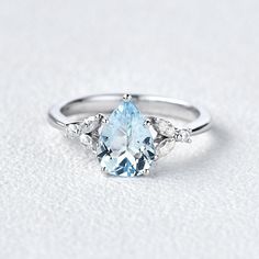 an oval blue topaz ring with three pear shaped diamonds