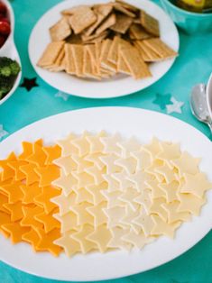 cheese and crackers arranged in the shape of stars on white plates with blue tablecloth