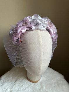 "This is a vintage 1950s purple fascinator with purple tulle birdcage veil, velvet bow and faux floral details. This piece is in good vintage condition, with small deep orange spots on internal wiring wrapped in purple velvet due to age and wear. Minimal staining can be viewed from outside of fascinator. Length: 12\" / Width: 7\" ALL SALES ARE FINAL. Unless otherwise stated all vintage items are used and may have minor to moderate wear or discoloration considering the age of the item. Most items Purple Headband With Handmade Flowers, Purple Handmade Flowers Headband, Purple Fascinator With Handmade Flowers For Parties, Purple Party Fascinator With Handmade Flowers, Purple Handmade Flowers Fascinator For Party, Purple Headpiece With Handmade Flowers For Kentucky Derby, Purple Handmade Flowers Headpiece For Kentucky Derby, Whimsical Purple Fascinator For Parties, Spring Wedding Lavender Headpiece