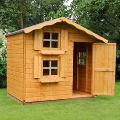 a small wooden shed sitting in the grass