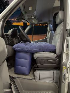 the interior of a van with its door open and seat cushions folded down on it