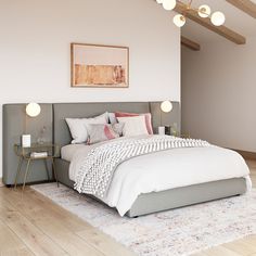 a large bed sitting in the middle of a bedroom next to a wooden floor and white walls