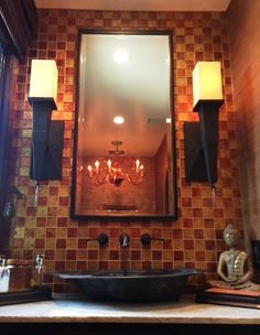 a bathroom sink with a mirror above it and lights on the wall next to it