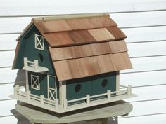 a green birdhouse with a brown roof