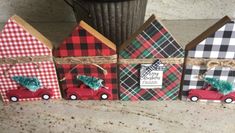 four small houses are decorated with plaid and pine tree decorations, tied in twine