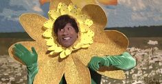 a man in a yellow flower costume with his arms out