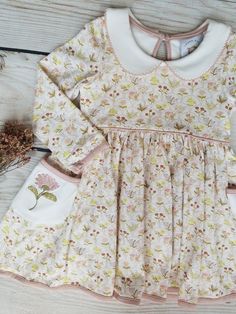 Swoon Baby Autumn Wildflower Embroidery Pocket Dress Style 23-26. Ready to ship! Description: This beautiful dress is made of high quality knit fabric. Swoon Baby knits are extremely soft and comfortable. Sizing: Swoon Baby fits true to size. We offer matching bows & knee high socks in our main menu. Link: https://southernsweetchildren.com/collections/accessories?page=1 If you have any questions or need a measurement, please contact our shop at amanda@southernsweetchildren.com Long Sleeve Cotton Dress With Floral Applique, Playful White Embroidered Dress, Playful Pink Embroidered Dresses, Cream Cotton Dress For Garden Party, Cute Cotton Floral Print Dresses, Cute Cotton Dresses With Floral Print, Cute Long Sleeve Cotton Dress, Cute Cotton Dress With Floral Print, Long Sleeve Cotton Dress With Floral Embroidery