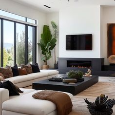 a living room filled with furniture and a flat screen tv mounted on the wall above a fire place