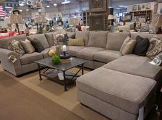 a living room filled with lots of couches and pillows on top of a rug