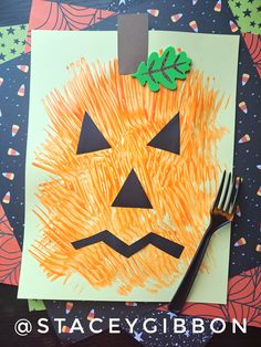 a paper plate with an orange pumpkin cut out on it and a fork next to it