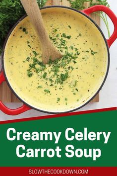 creamy celery carrot soup in a red pot with a wooden spoon on the side