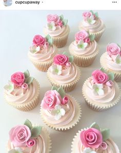 cupcakes with pink frosting and roses on them are arranged in a row