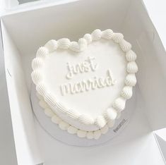 a heart shaped cake in a white box with the words just married written on it